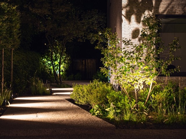 Verlicht tuinpad naar de achterkant van een woning.