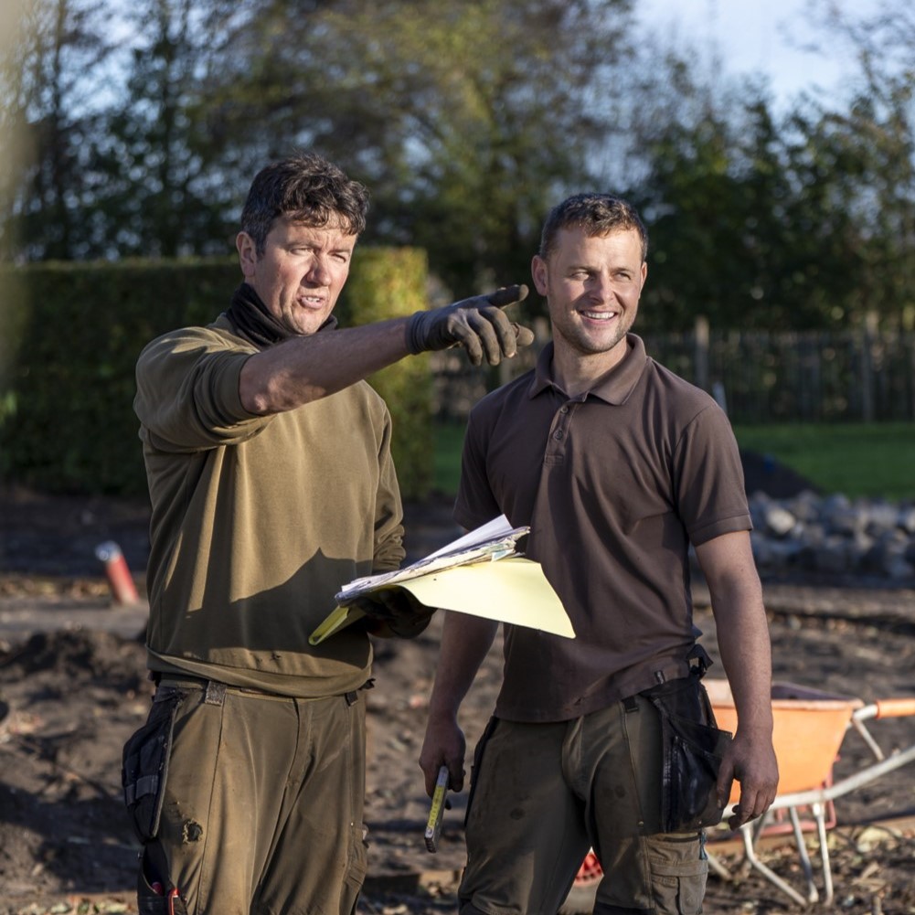 Twee experts van Gard'Or bekijken het tuinplan op een werf.